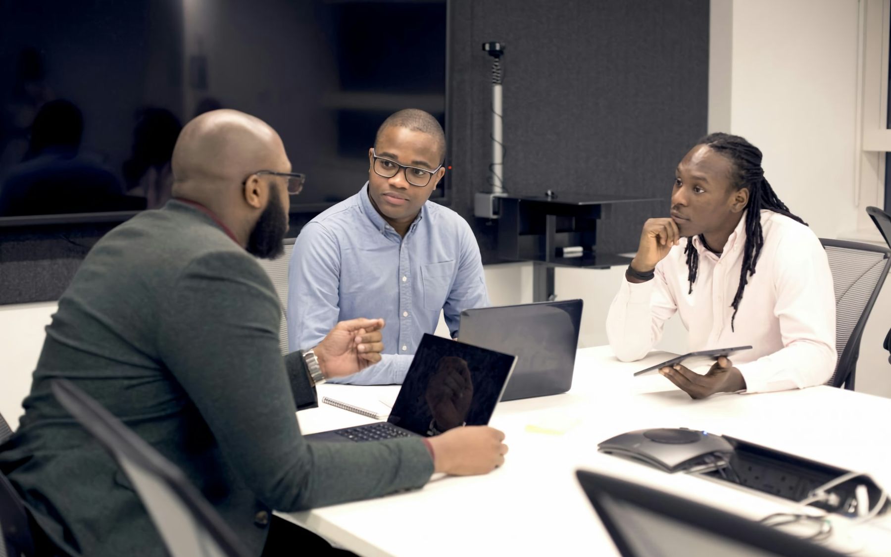 A business team discussing work around laptops in an office