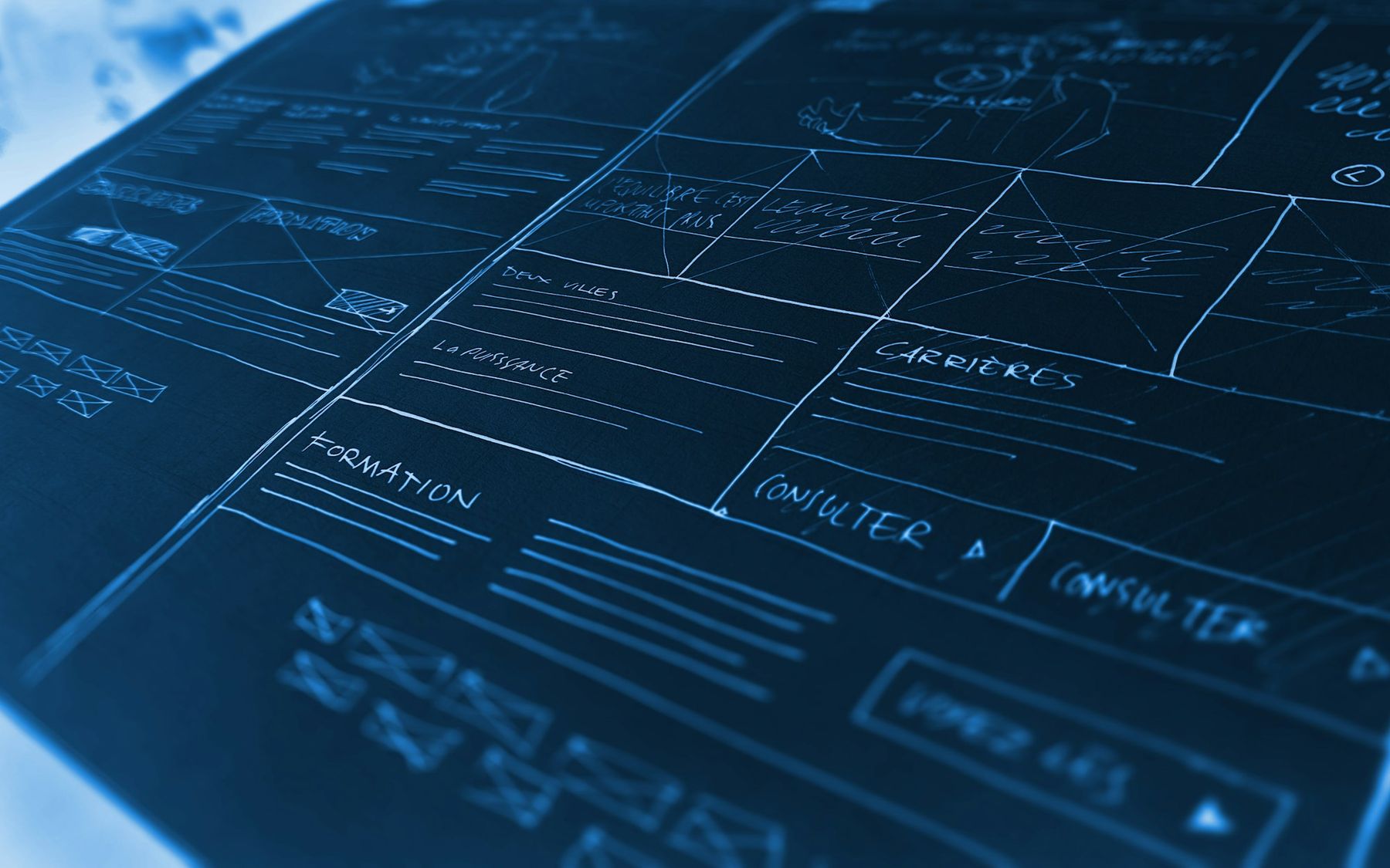 Hand-drawn website wireframes on a blue background