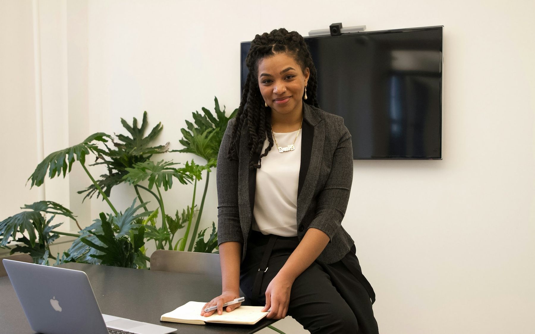 A business leader standing beside her desk in a bright office